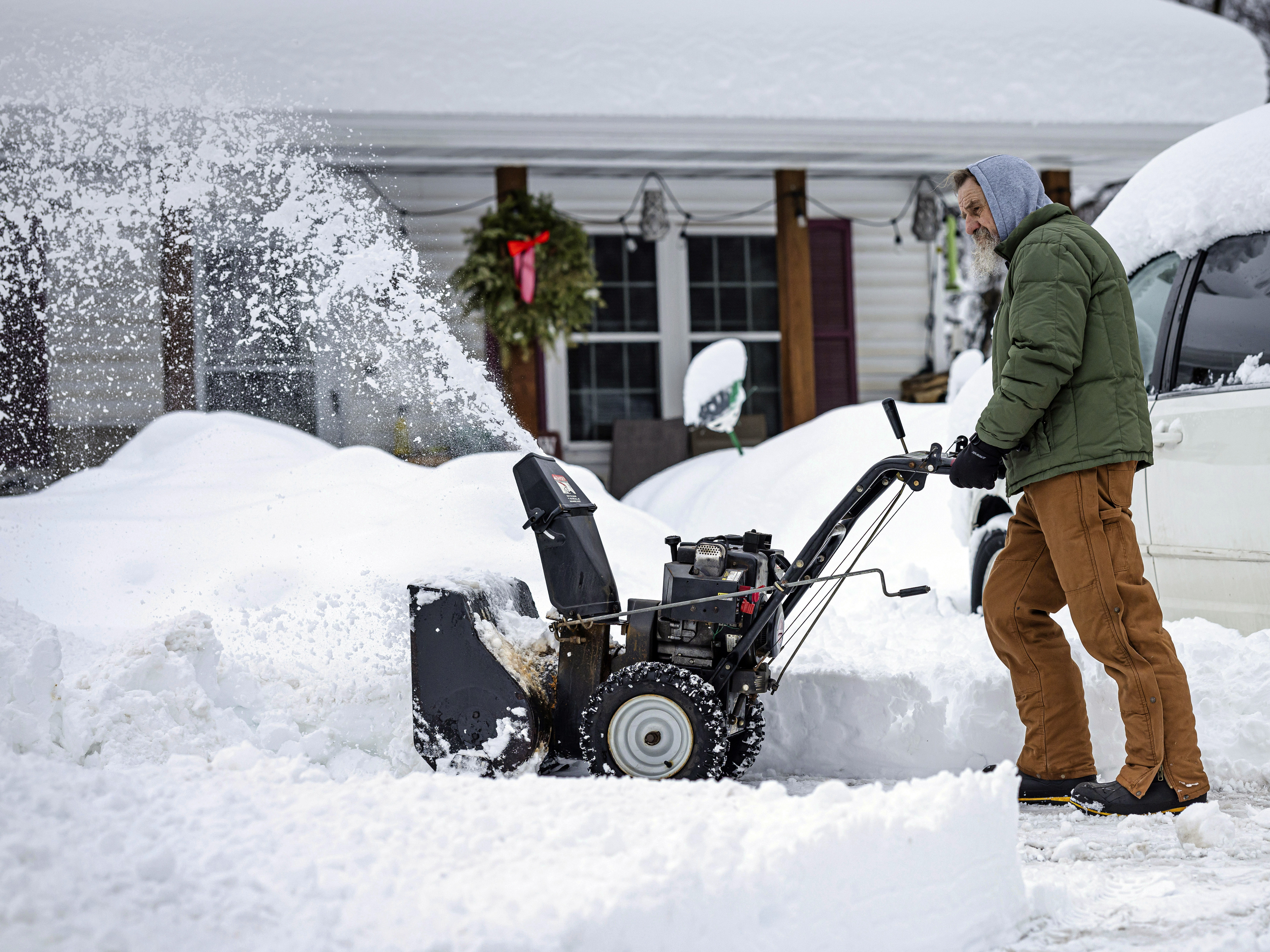 caption: A man clears a driveway after a snow storm passed through northern Minnesota last week. Forecasters say another big storm is expected to hit the region this week.