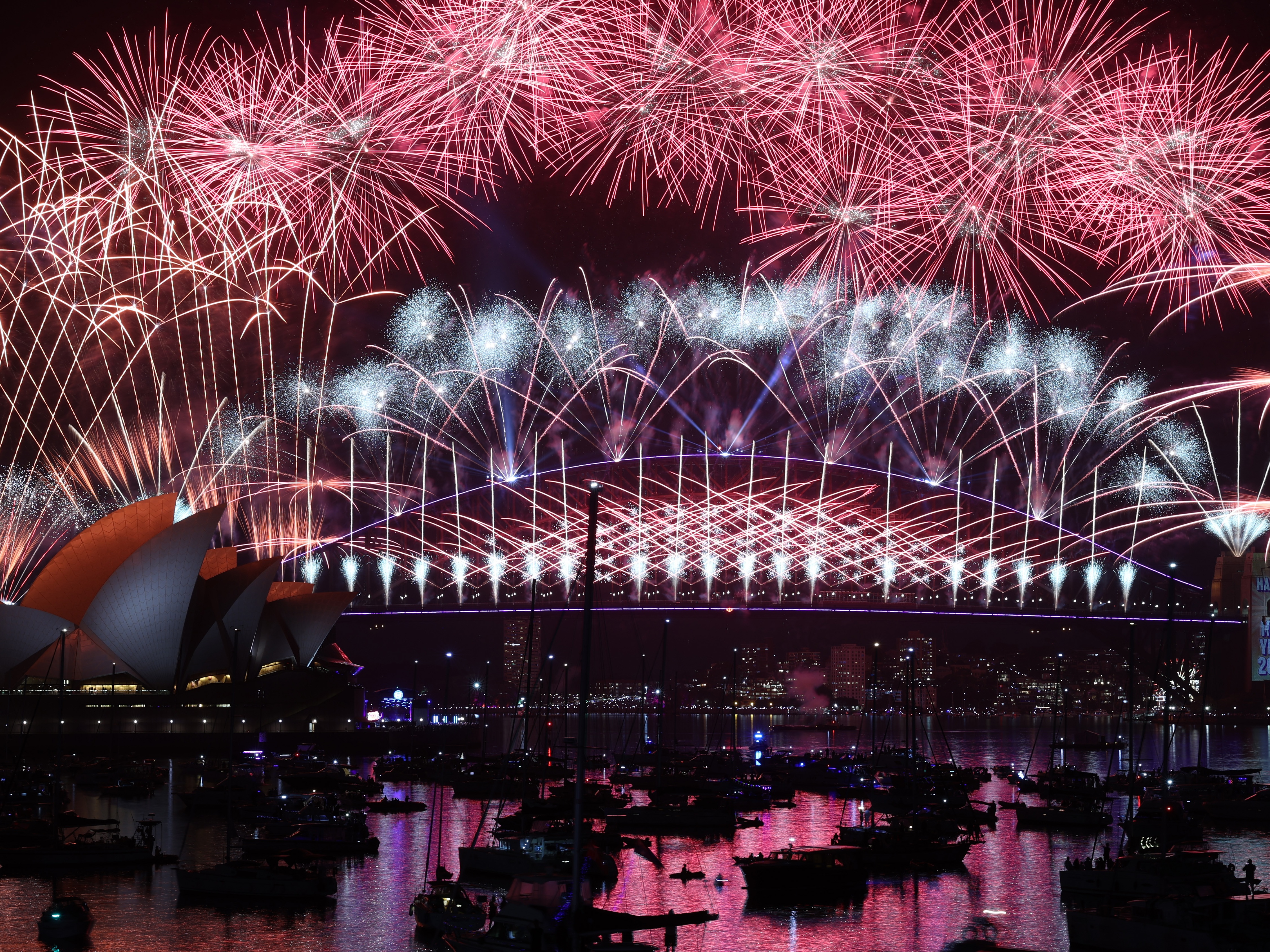 caption: Fireworks light up the sky over the Sydney Harbour Bridge and the Sydney Opera House during New Year's Eve celebrations on January 01, 2026 in Sydney, Australia. (