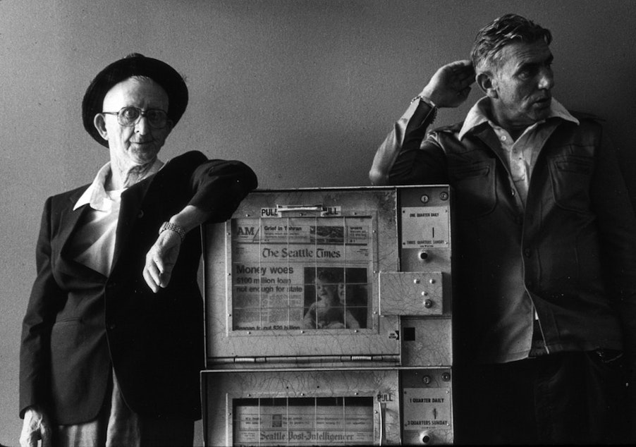 caption: Men with newspaper box, 1981