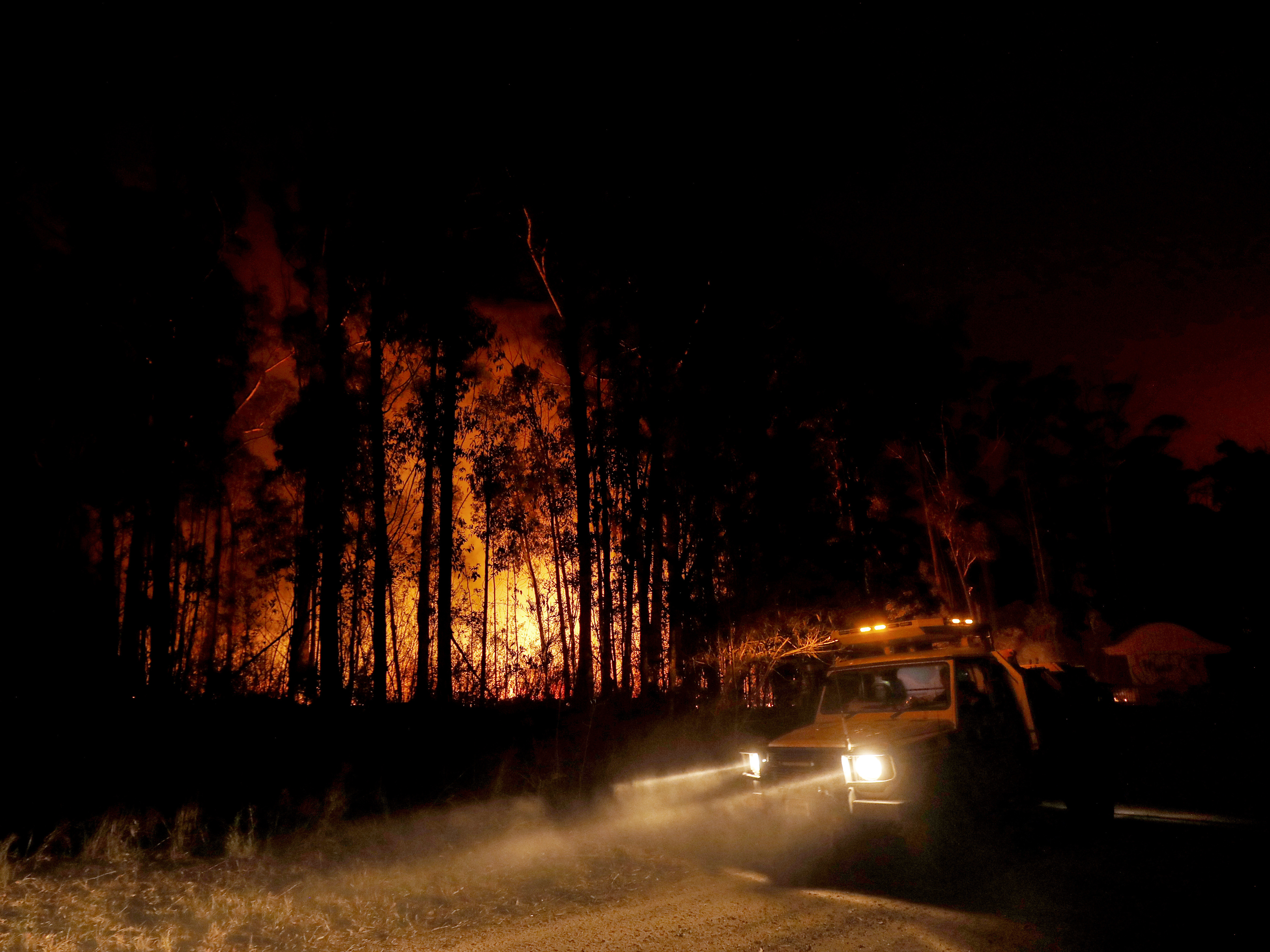 caption: Fire response crews monitor the blazes Thursday in East Gippsland, Australia, where deadly bushfires have destroyed properties and prompted warnings from local authorities.
