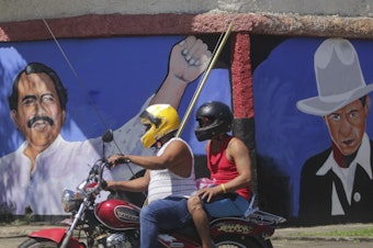caption: A motorcyclist rides past a mural of Nicaraguan President Daniel Ortega, left, and revolutionary hero CÃ©sar Augusto Sandino<em> </em>during general elections in Managua, Nov. 7, 2021. Ortega won a fourth consecutive term against a field of little-known candidates while those who could have given him a real challenge sat in jail.