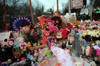 caption: A makeshift shrine to the victims of the Sandy Hook Elementary school shooting is set up shortly after the massacre in December 2012 in Newtown, Conn.