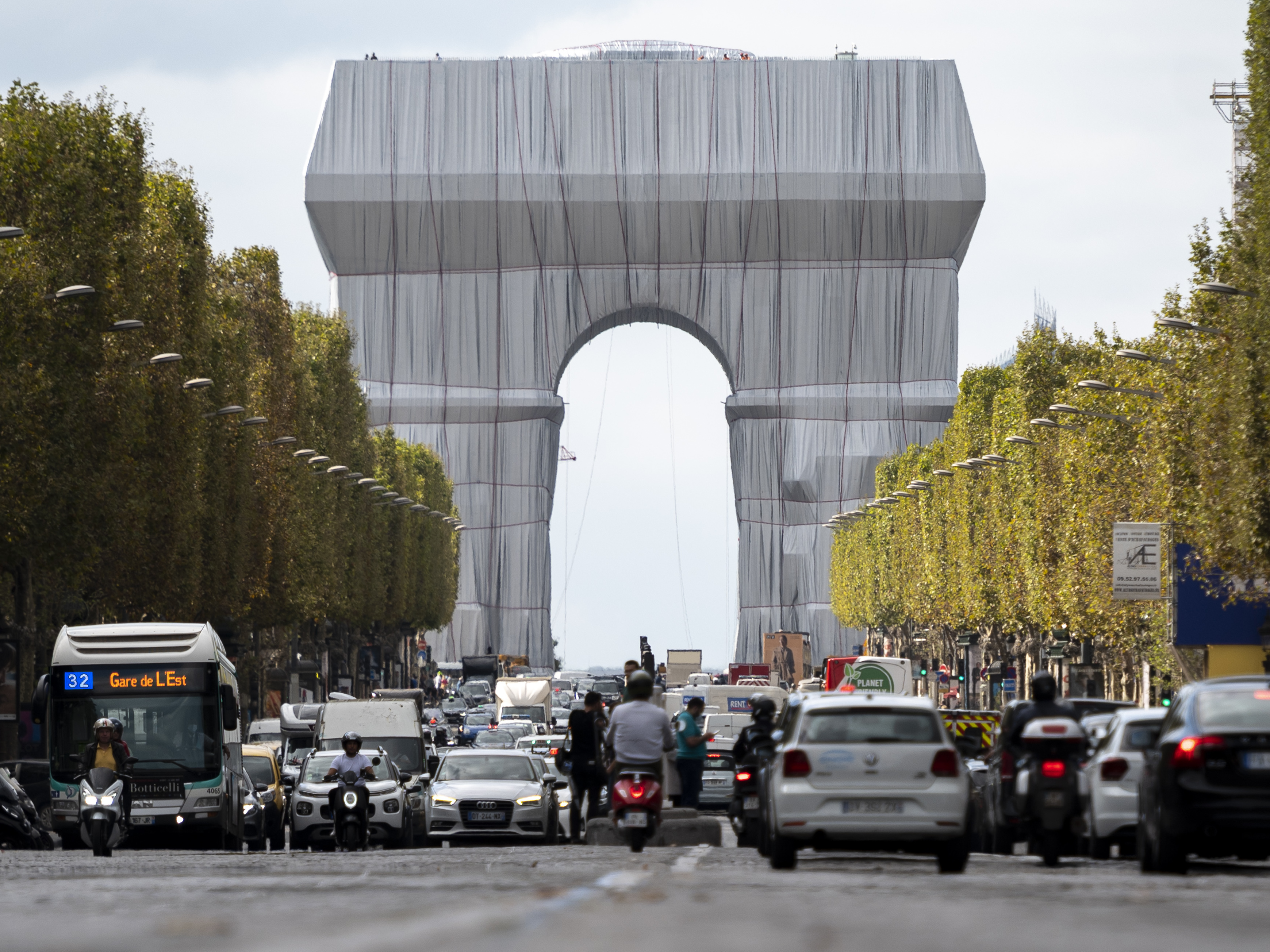caption: The Arc de Triomphe in Paris is seen wrapped in fabric, in a posthumous art project that is an homage to the late artists Christo and Jeanne-Claude .