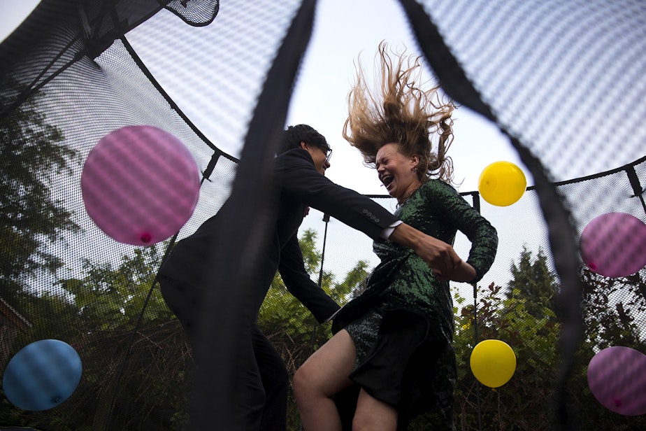 caption: Leo Padua, a 17-year-old senior at Ingraham High School, and Morgen White, right, an 18-year-old senior at Ballard High School, jump on a trampoline with balloons during their own personal prom celebration in Leo's backyard on Saturday, May 23, 2020, in Seattle. "It feels like a little bit of childhood that I missed," said White. "It’s this point where you’re supposed to become an adult but it feels like it didn’t happen."