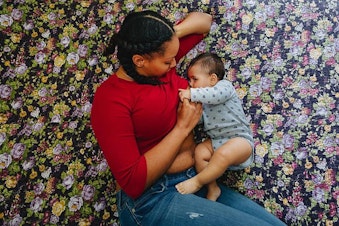 caption: Sharayah Lane, a graduate student at the University of Washington, nurses her son Ian, 8 months.
