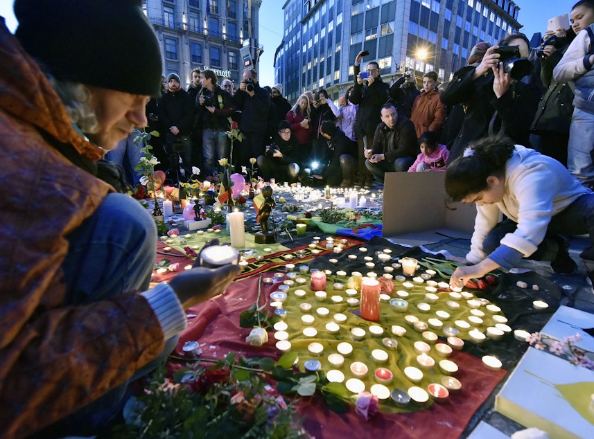 caption: People bring flowers and candles to mourn for the victims at Place de la Bourse in the center of Brussels, Tuesday, March 22, 2016. 