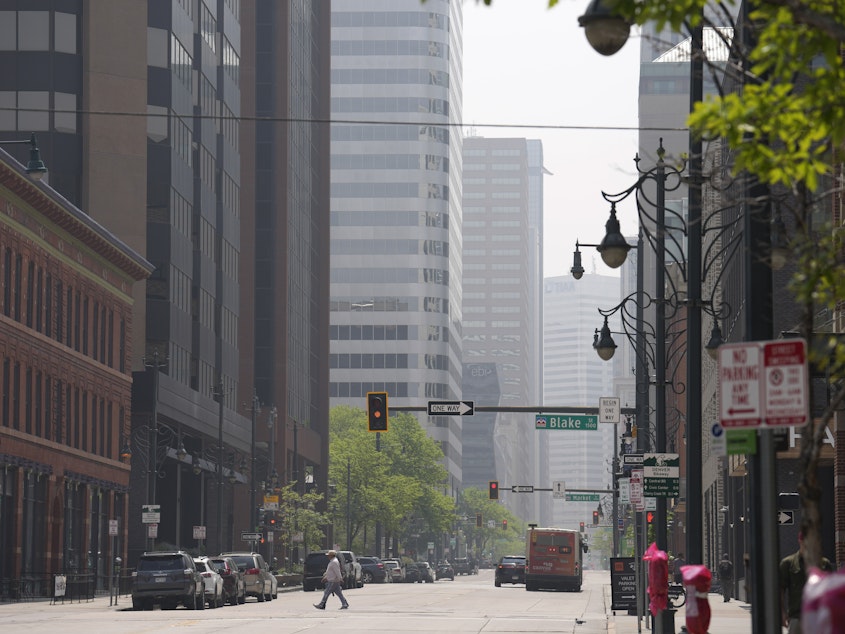 caption: A smoky haze shrouds the high-rise buildings in downtown Denver on Saturday, May 20.