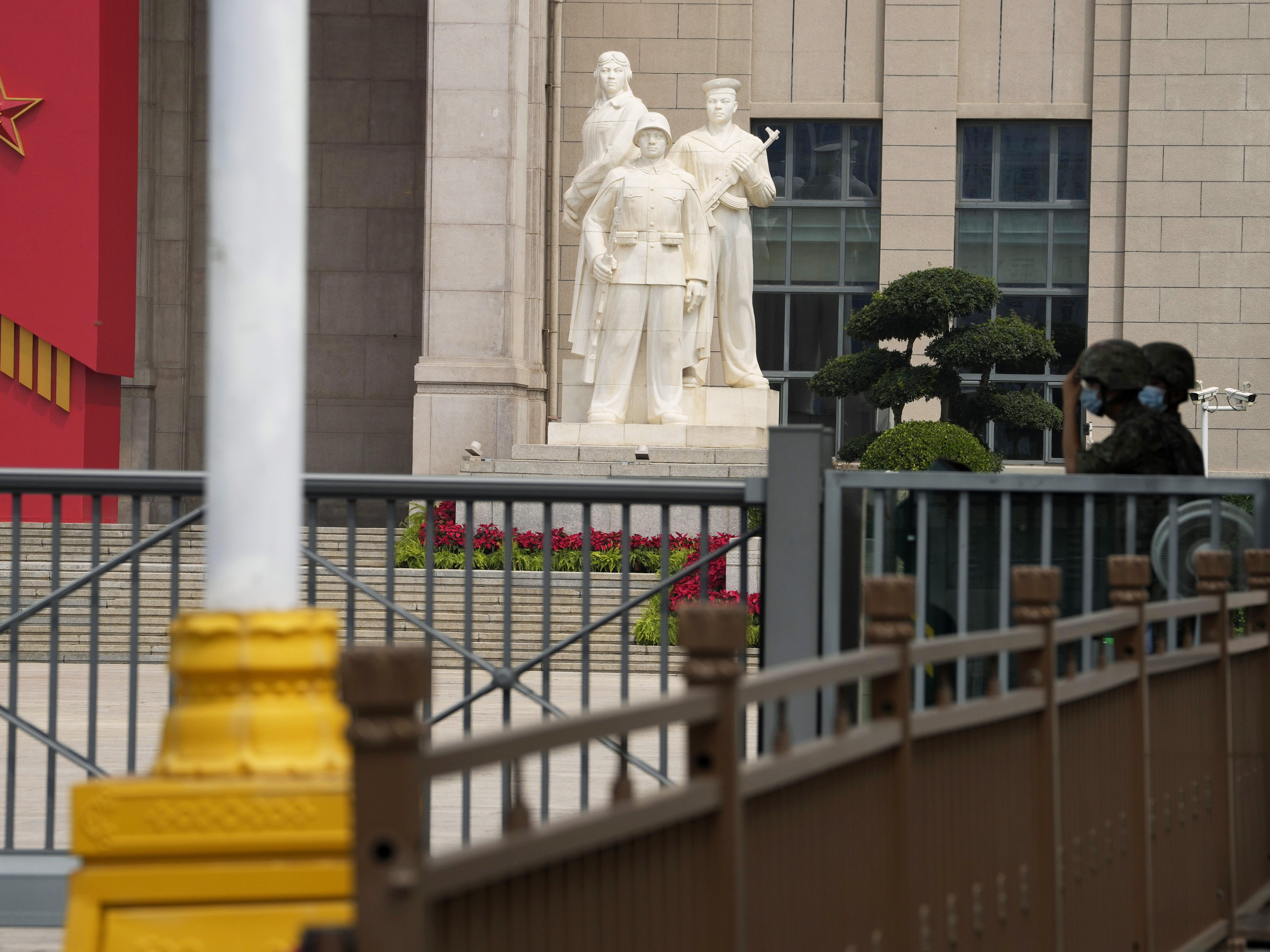 caption: Chinese soldiers wearing masks guard the entrance to the military museum in Beijing on Aug. 1. China says military exercises by its navy, air force and other departments are underway in six zones surrounding Taiwan.