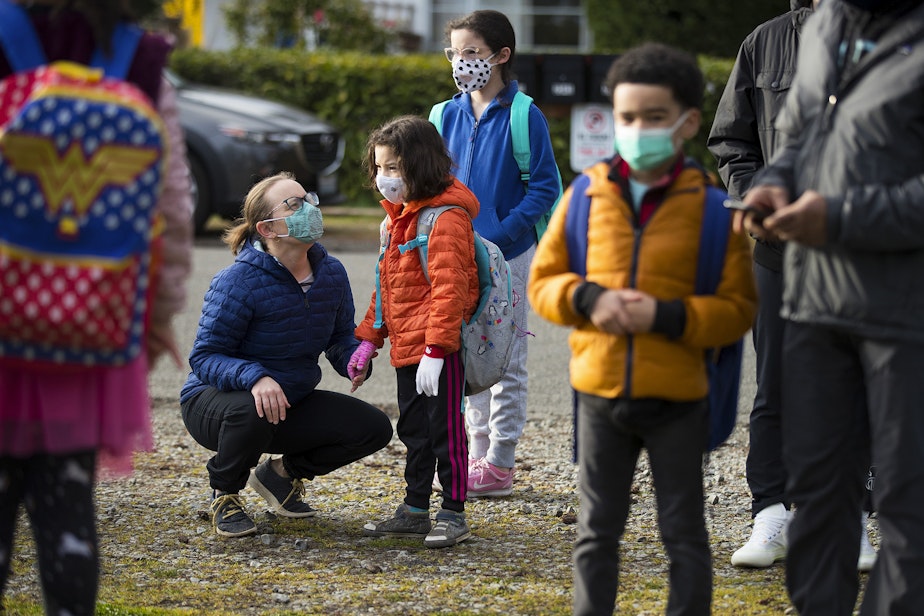 caption: Lisa Schafer says goodbye to her daughter, 1st-grade student Adrianna Branksky, on Monday, April 5, 2021, on the first day of in-person learning at Northgate Elementary School in Seattle.