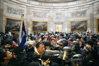 caption: Police clash with supporters of President Donald Trump who breached security and entered the Capitol building in Washington D.C., on Jan. 6, 2021.