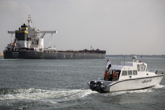 caption: Traffic through the Suez Canal has returned to normal, the canal authority says. Here, the Huahine is seen crossing the canal on March 30 in Ismailia, Egypt.