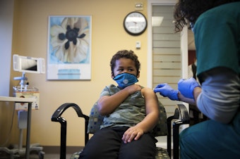 caption: Isaac Williams, 6, wears a mask as he prepares to receive a dose of the Covid-19 vaccine on Tuesday, November 9, 2021, at Seattle Children's Hospital in Seattle. Wash. Gov. Inslee said on Feb. 9, 2022 that the state was not joining the decision of other states to end mask requirements.  