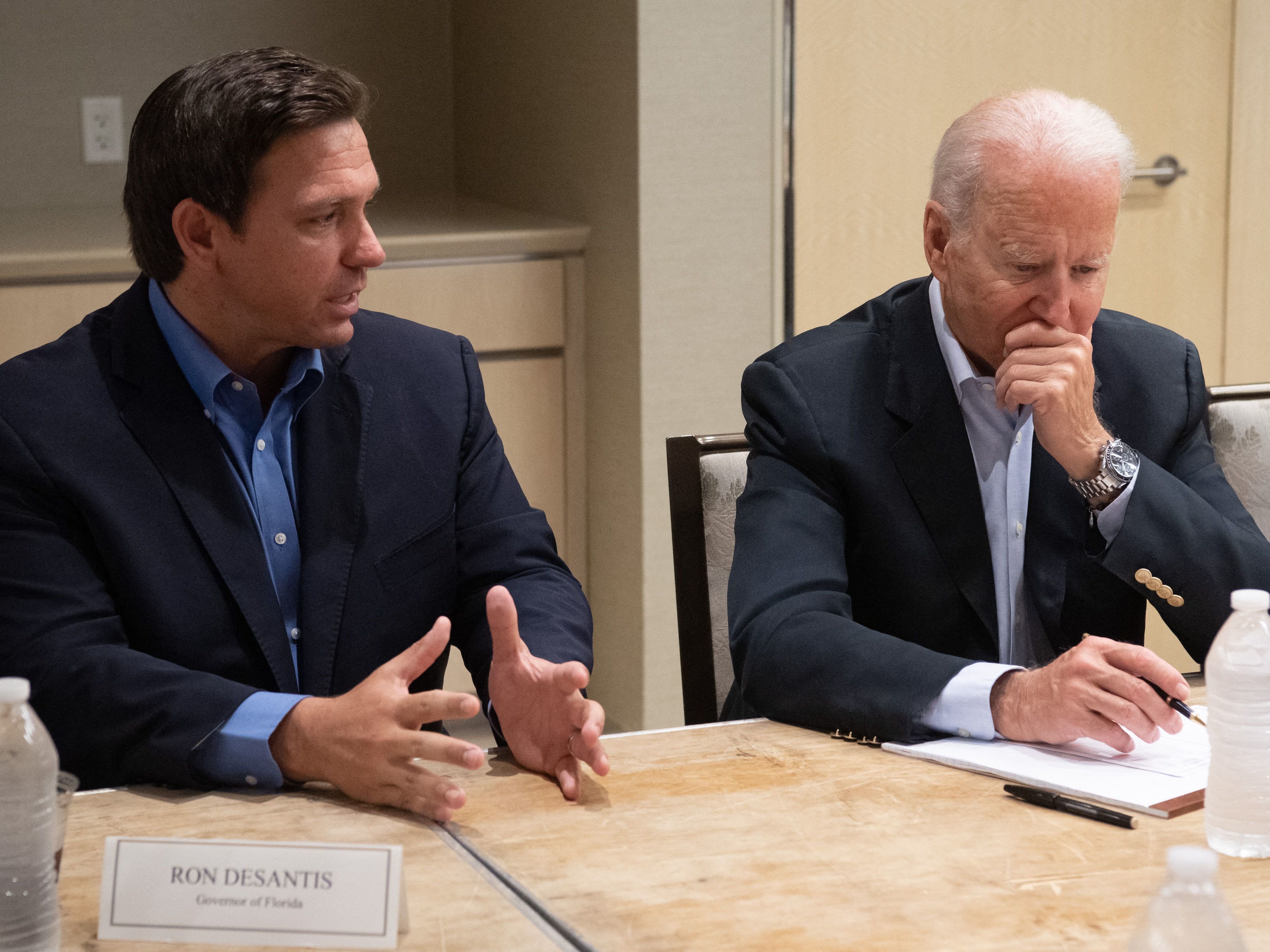 caption: President Biden listens Thursday as Florida Gov. Ron DeSantis discusses the collapse of the 12-story Champlain Towers South condo building in Surfside, Fla.