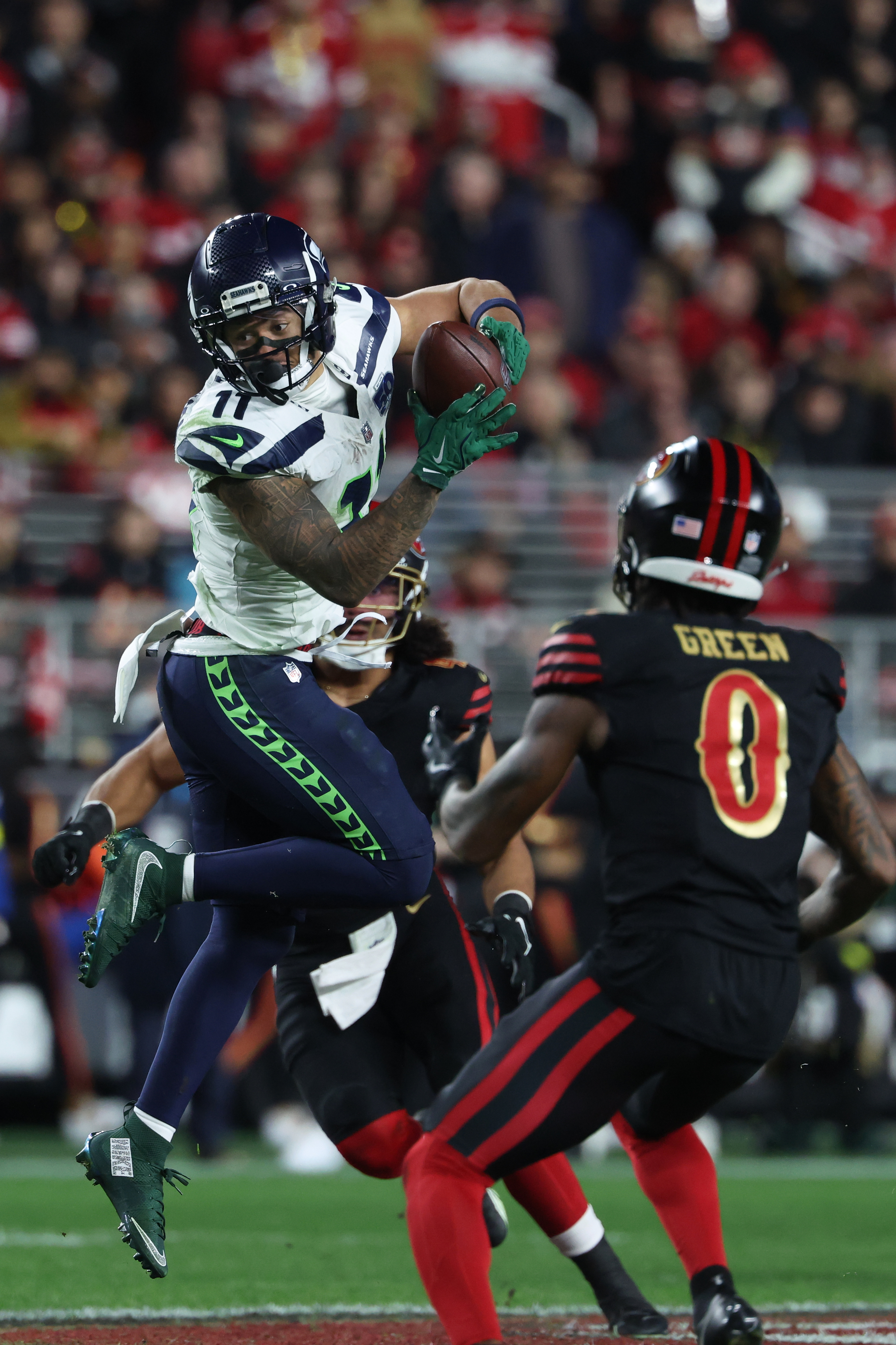 caption: Seattle Seahawks wide receiver Jaxon Smith-Njigba, left, catches a pass against San Francisco 49ers cornerback Renardo Green (0) and middle linebacker Eric Kendricks, rear, during the second half of an NFL football game in Santa Clara, Calif., Saturday, Jan. 3, 2026. 