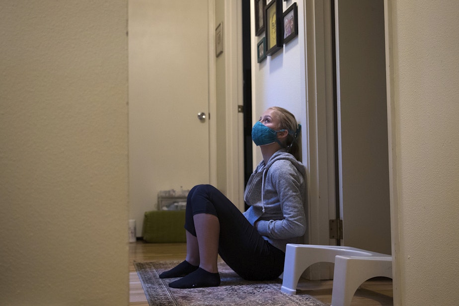 caption: Doula Solrun Heuschert waits in the hallway at 6:03 a.m. after a long night of labor, on Friday, May 28, 2020, at Hope and Jake Black's home on Vashon Island.