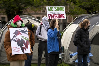 caption: University of Washington students set up what they are calling the UW Palestine Encampment on Monday, April 29, 2024, in Seattle. 