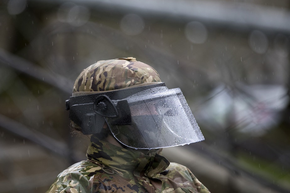caption: In this file photo, a member of the National Guard stands at the Washington State Capitol ahead of the beginning of the legislative session January 11, 2021 in Olympia.