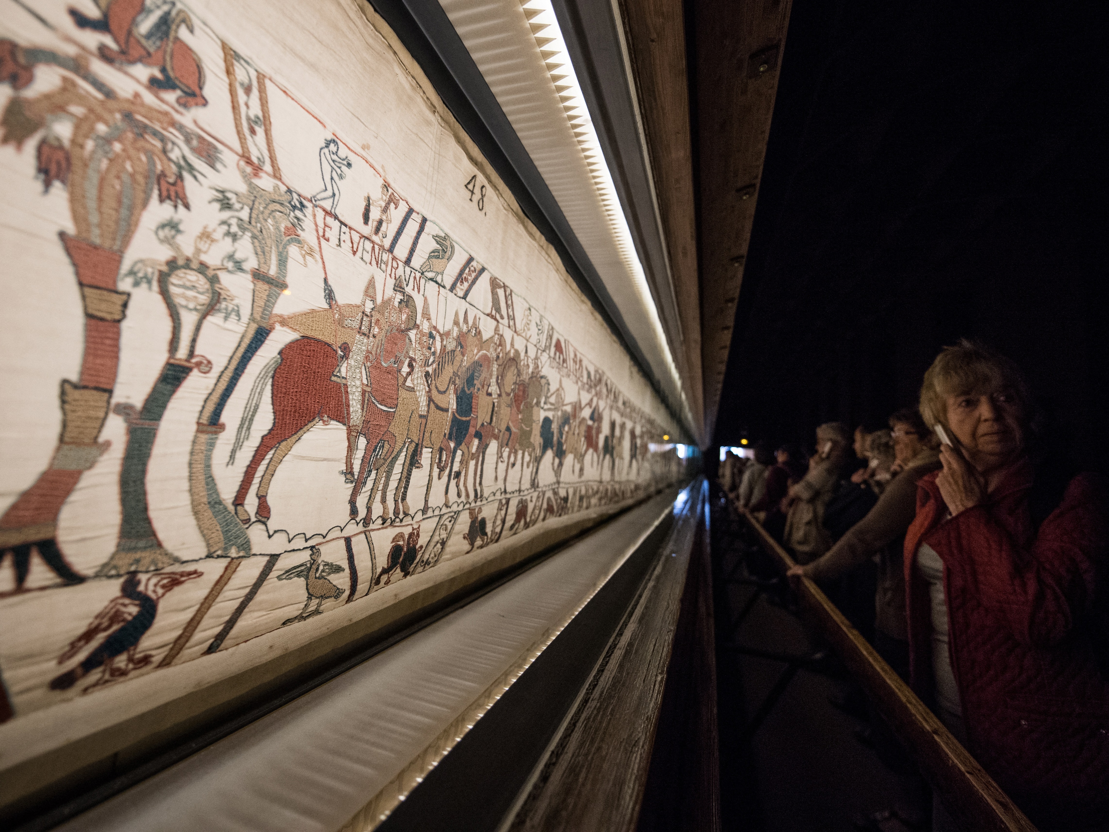 caption: People look at the Bayeux tapestry in Bayeux, western France, on Sept. 13, 2019.