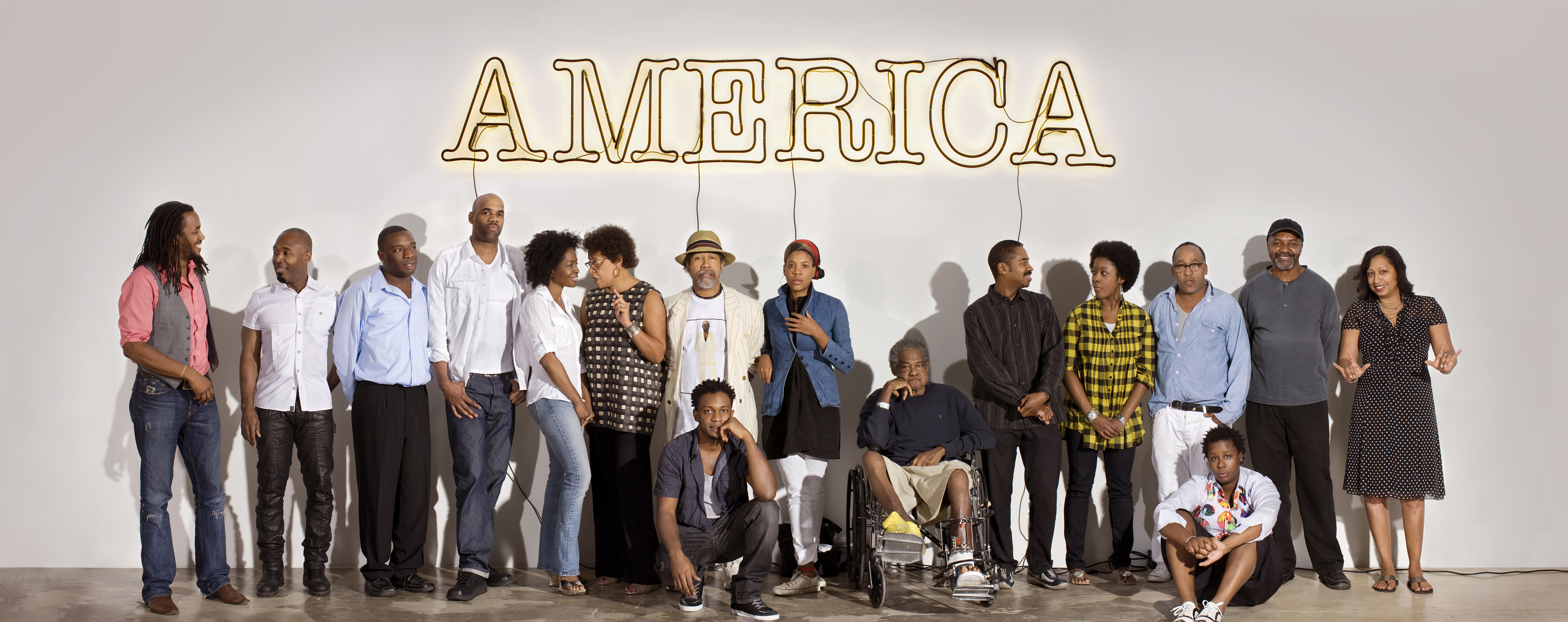 caption: Some of the artists represented in "30 Americans" pose beneath a neon artwork created by Glenn Ligon. Click through for more photos of the art.