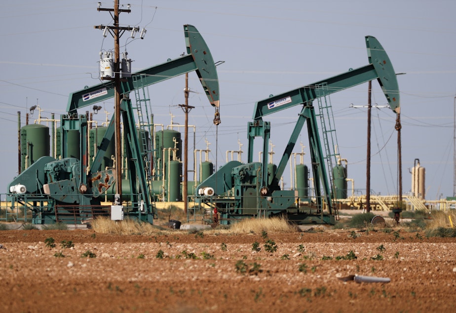 caption: In this July 29, 2020 file photo, a view of a pump jack operating in an oil field in Midland, Texas.