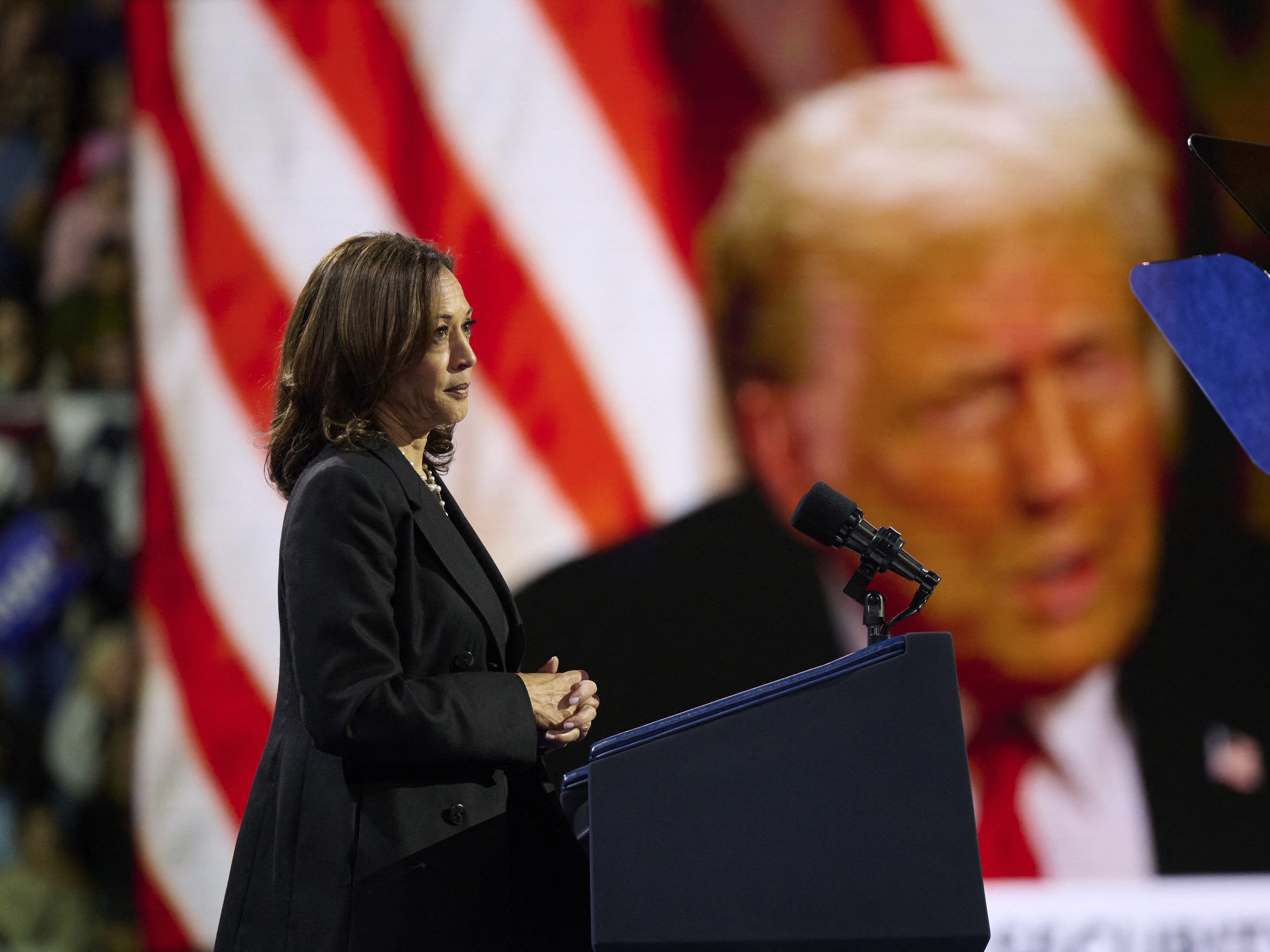 caption: Vice President Harris plays a highlight reel of her opponent, former President Donald Trump, during a rally in Erie, Pa., on Oct. 14, 2024.