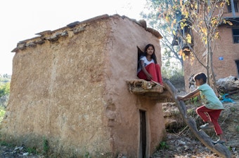 caption: Manisha Jaisi, 16, poses at the shed outside her house where she sleeps when she has her period. Jaisi got her period two months after her neighbor, Dambara Upadhyay, died while sleeping in a similar shed in 2016 of unknown causes. Jaisi says she never goes without her phone in the shed because she's scared after Upadhyay's death.