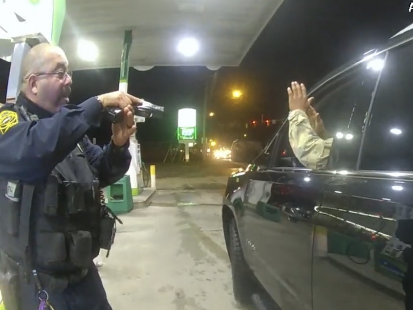 caption: Officer Joe Guttierez aims his weapon at Lt. Caron Navario during a traffic stop. Navario is suing Guttierez and the other officer, Daniel Crocker, for violation of his constitutional rights.