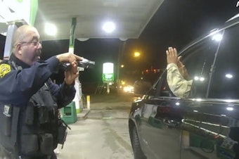 caption: Officer Joe Guttierez aims his weapon at Lt. Caron Navario during a traffic stop. Navario is suing Guttierez and the other officer, Daniel Crocker, for violation of his constitutional rights.