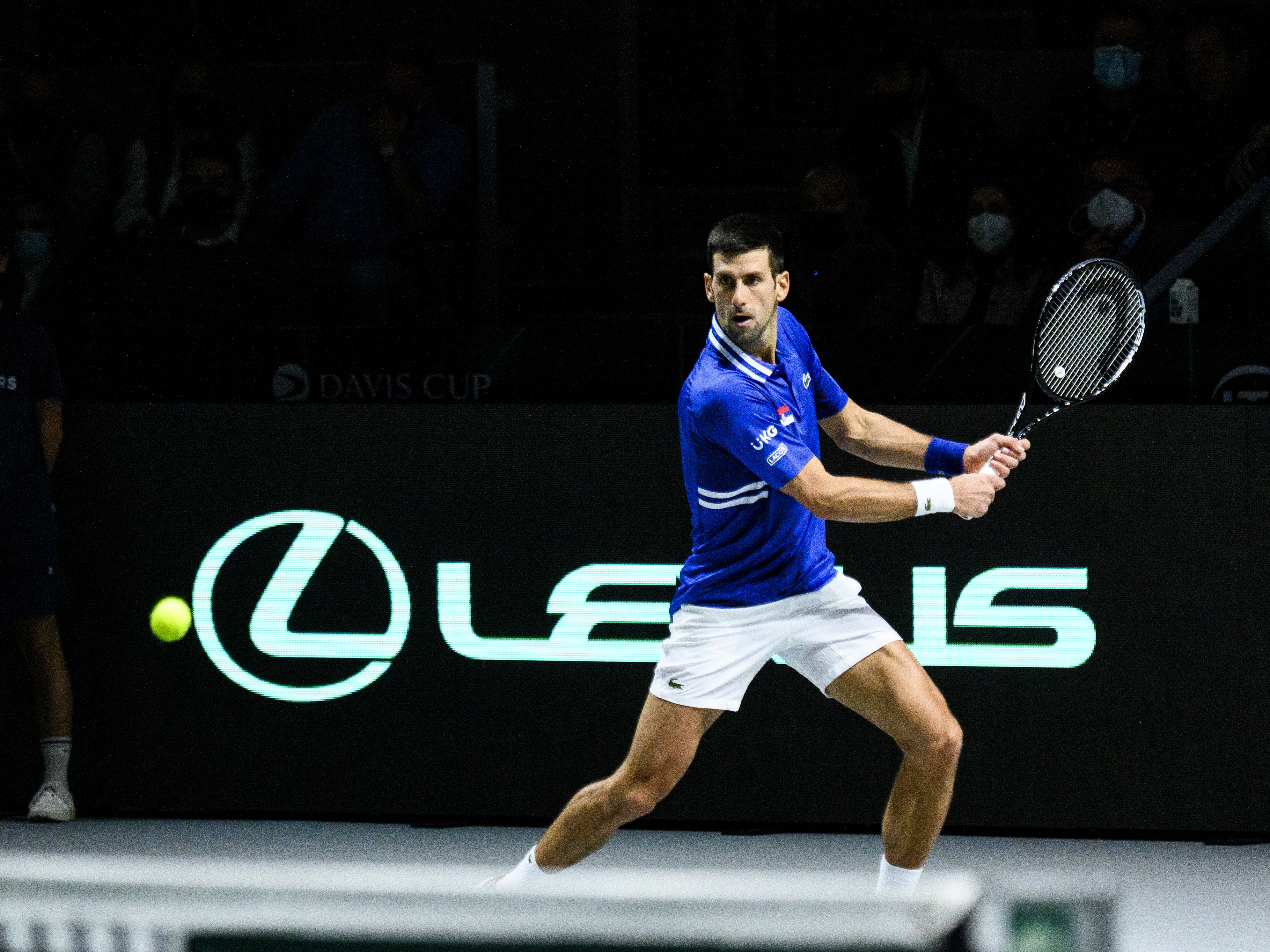 caption: Novak Djokovic of Serbia plays a backhand against Marin Cilic of Croatia during the Davis Cup Semi Final match between Croatia and Serbia at Madrid Arena pavilion in December in Madrid, Spain.