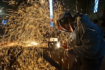 caption: A welder at Vigor Industrial works on a new ferry for the Washington State Ferry System.