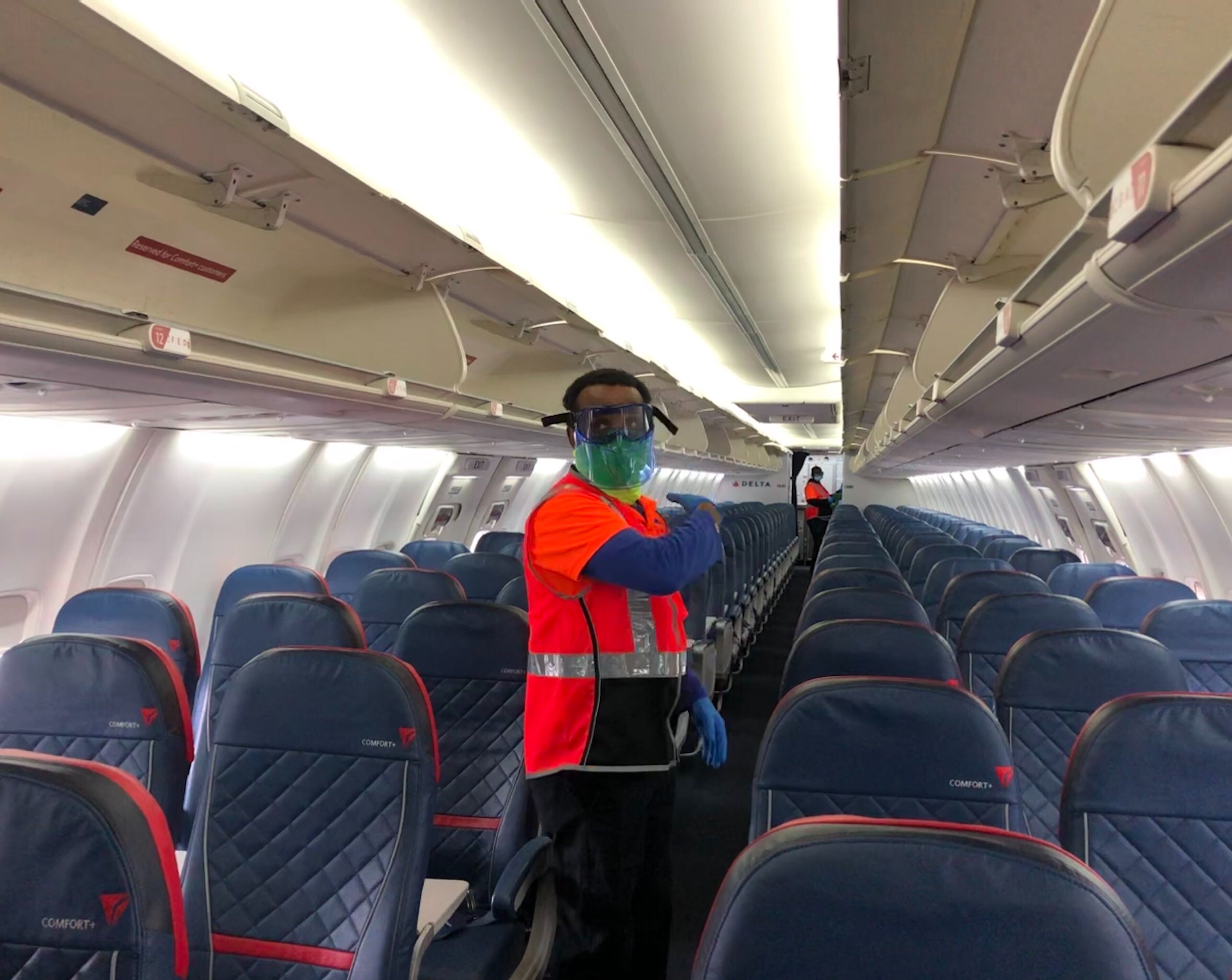 caption: Lemlem Awraris of ERMC Aviation services prepares to fog a Delta Air Lines plane with disinfectant on Wednesday, June 17, 2020. 