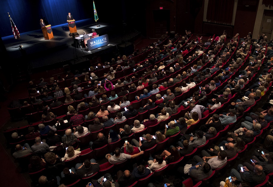 caption: Spectators pack McConnell Hall as 8th congressional district candidates Kim Schrier and Dino Rossi debate on Wednesday, October 17, 2018, at Central Washington University in Ellensburg. Tap or click on the first image to see more.