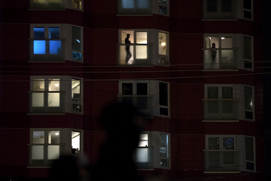 caption: People watch from their apartment windows and various protest groups join together before marching on the night of the 2020 Presidential election on Tuesday, November 3, 2020, at Cascade Playground in Seattle.