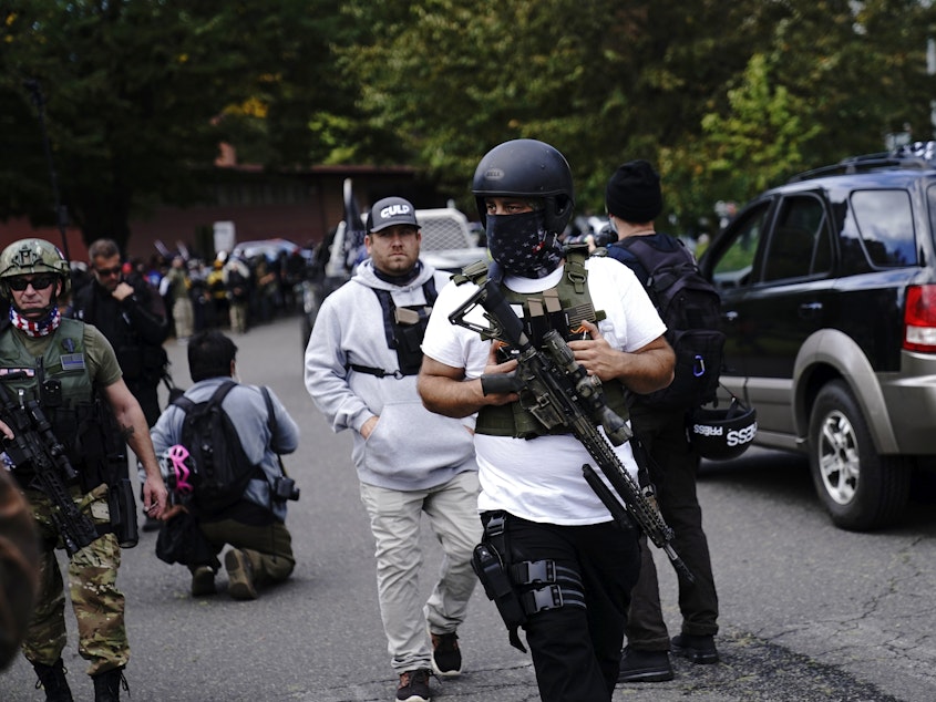 caption: Armed participants walk at a Proud Boys rally with other right-wing demonstrators in September 2020 in Portland, Ore. Far-right groups celebrated the verdict in the Rittenhouse trial.