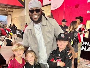 caption: The Phillips family with their new favorite player, Jesse Luketa.