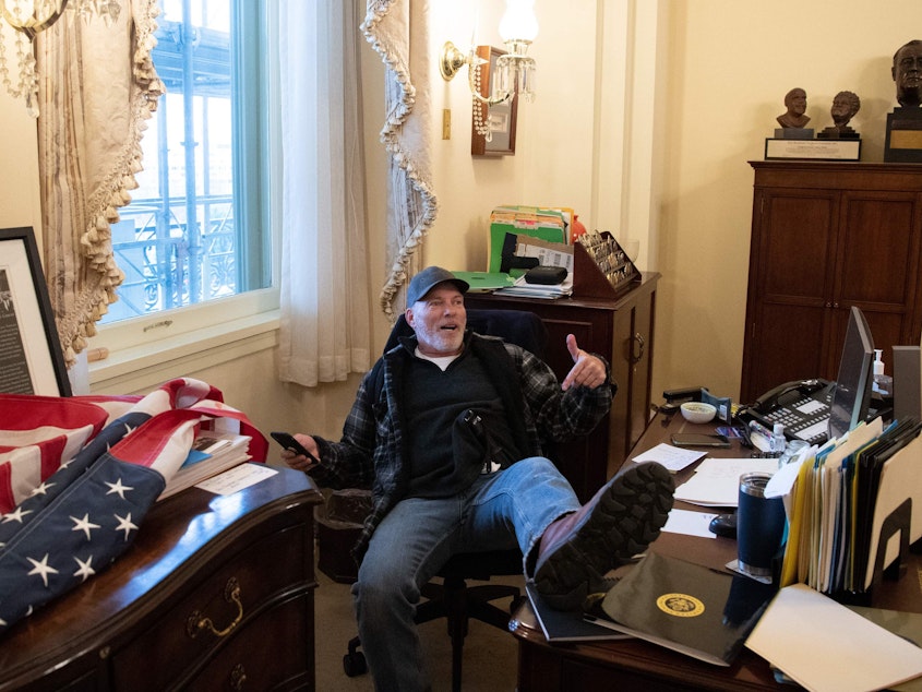 caption: Richard Barnett has been arrested in his home state of Arkansas and faces charges related to his part in the forced entry into the Capitol. During the riot, Barnett sat in House Speaker Nancy Pelosi's office.