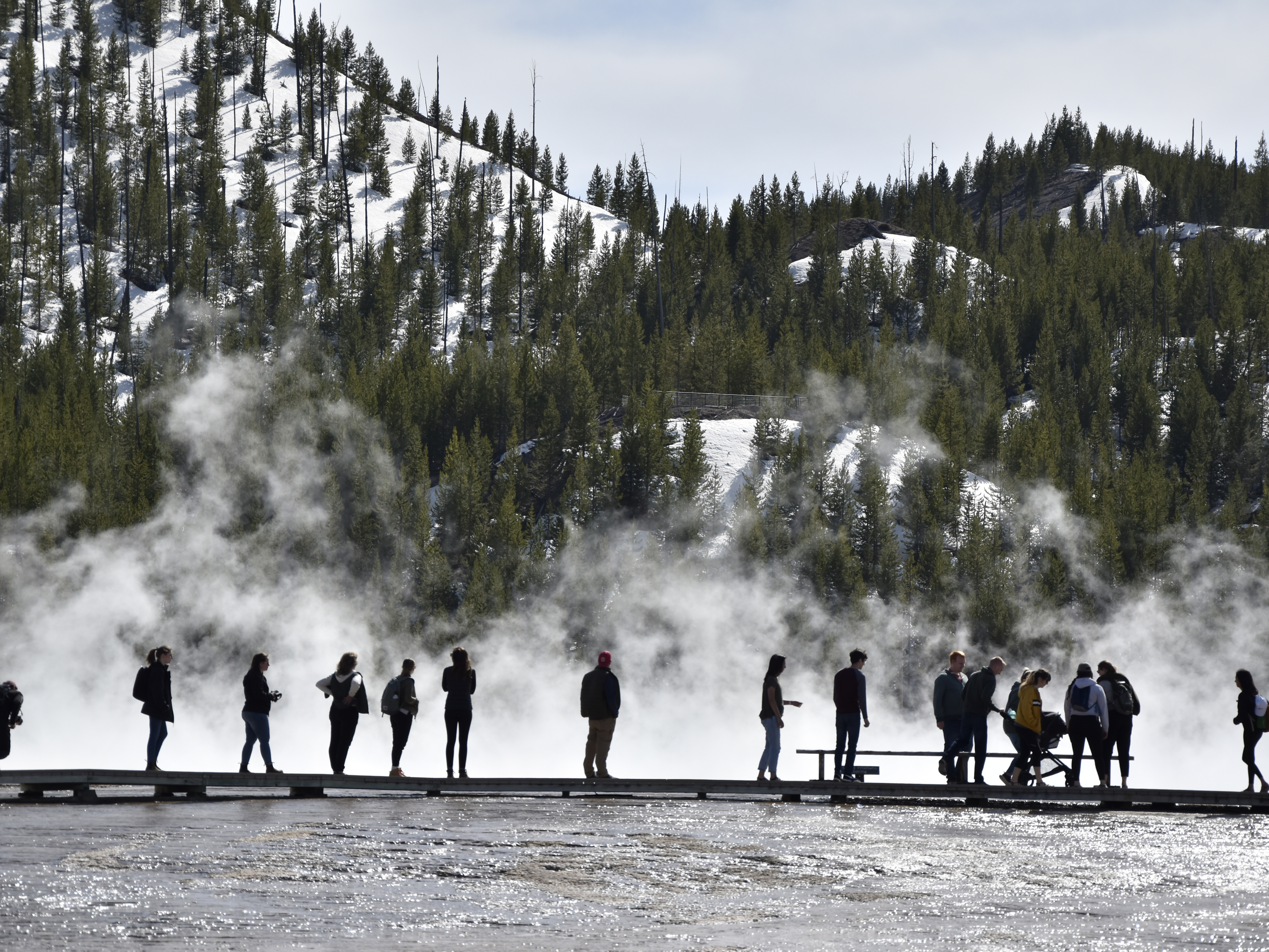 caption: Visitors are seen at Grand Prismatic Spring in Yellowstone National Park, Wyo., last year.