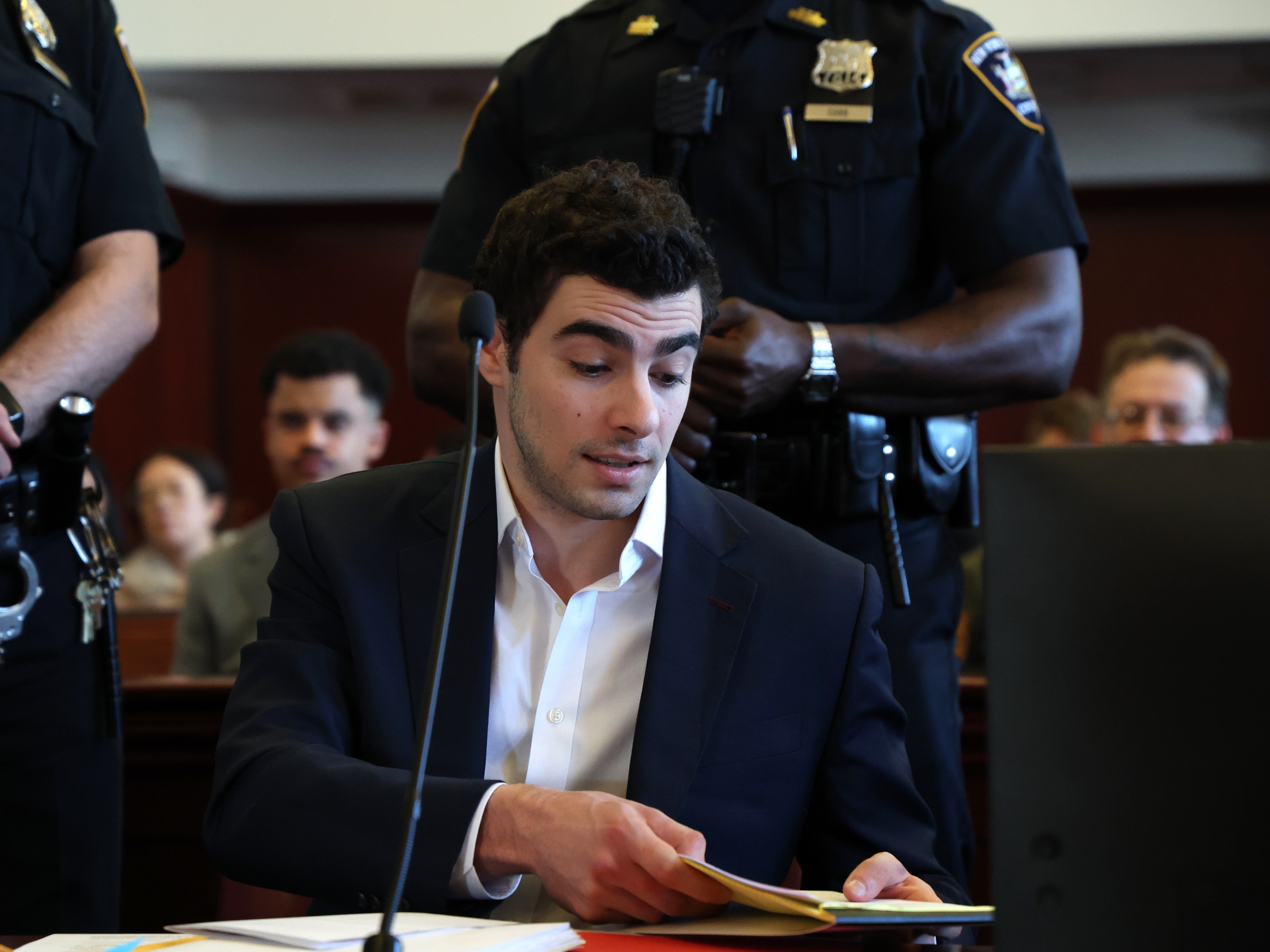 caption: Luigi Mangione appears in Manhattan Criminal Court for an evidence hearing, Thursday , Dec. 18, 2025, in New York.