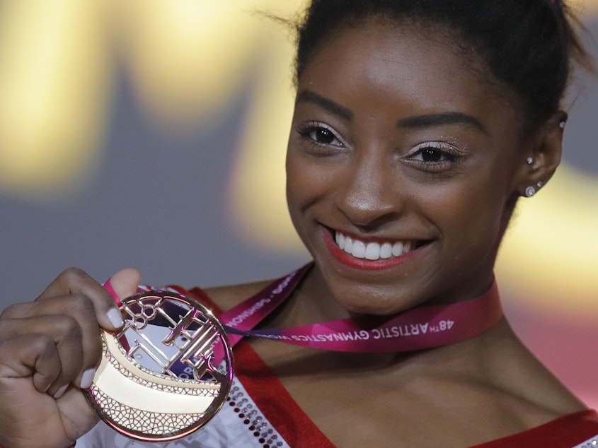 caption: Simone Biles of the U.S. shows her gold medal after the women's vault final at the gymnastics World Championships in Doha, Qatar last week.