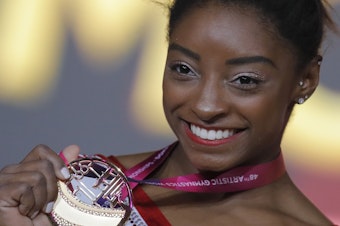 caption: Simone Biles of the U.S. shows her gold medal after the women's vault final at the gymnastics World Championships in Doha, Qatar last week.