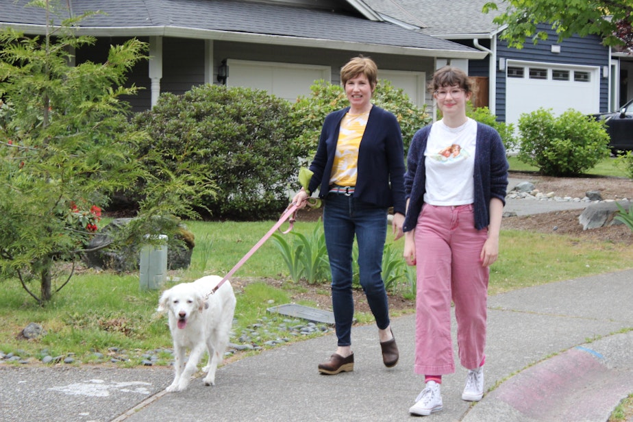 caption: Jennifer and Anya Davis, walking their dog Strawberry near their home.  