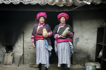 caption: Naju Dorma, 73, and Lacuo Dorma, 66, belong to the Mosuo society in China, where grandmothers head up households. They're posing in traditional garb in their village of Luoshui.