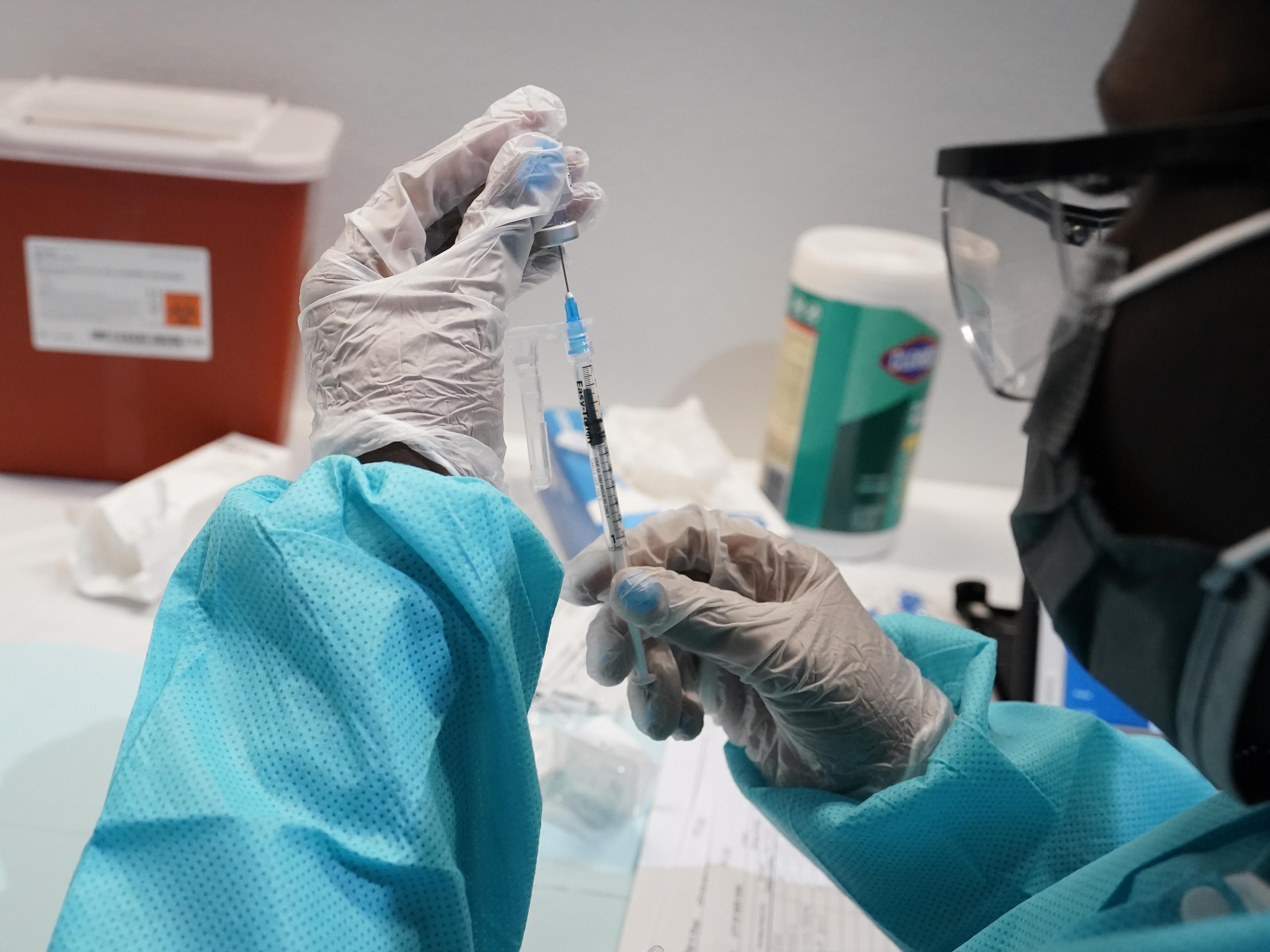 caption: A health care worker fills a syringe with the Pfizer COVID-19 vaccine in July in New York. U.S. officials are recommending that Americans get COVID-19 booster shots to shore up their protection amid the surging delta variant and evidence the vaccines' effectiveness is falling.