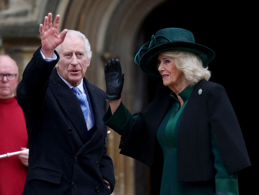 caption: Britain's King Charles III (center), next to Queen Camilla, waves as they arrive at St. George's Chapel, Windsor Castle, on March 31.