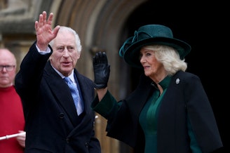 caption: Britain's King Charles III (center), next to Queen Camilla, waves as they arrive at St. George's Chapel, Windsor Castle, on March 31.