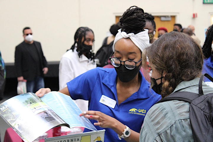 caption: A college expo worker explains opportunities to a student at the Black College Expo.