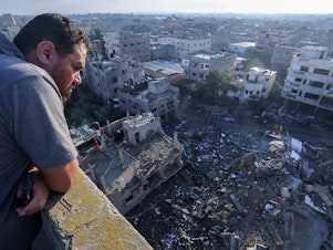 caption: A Palestinian man looks down at a building destroyed in an Israeli airstrike in the Rafah refugee camp in the southern Gaza Strip on Monday.