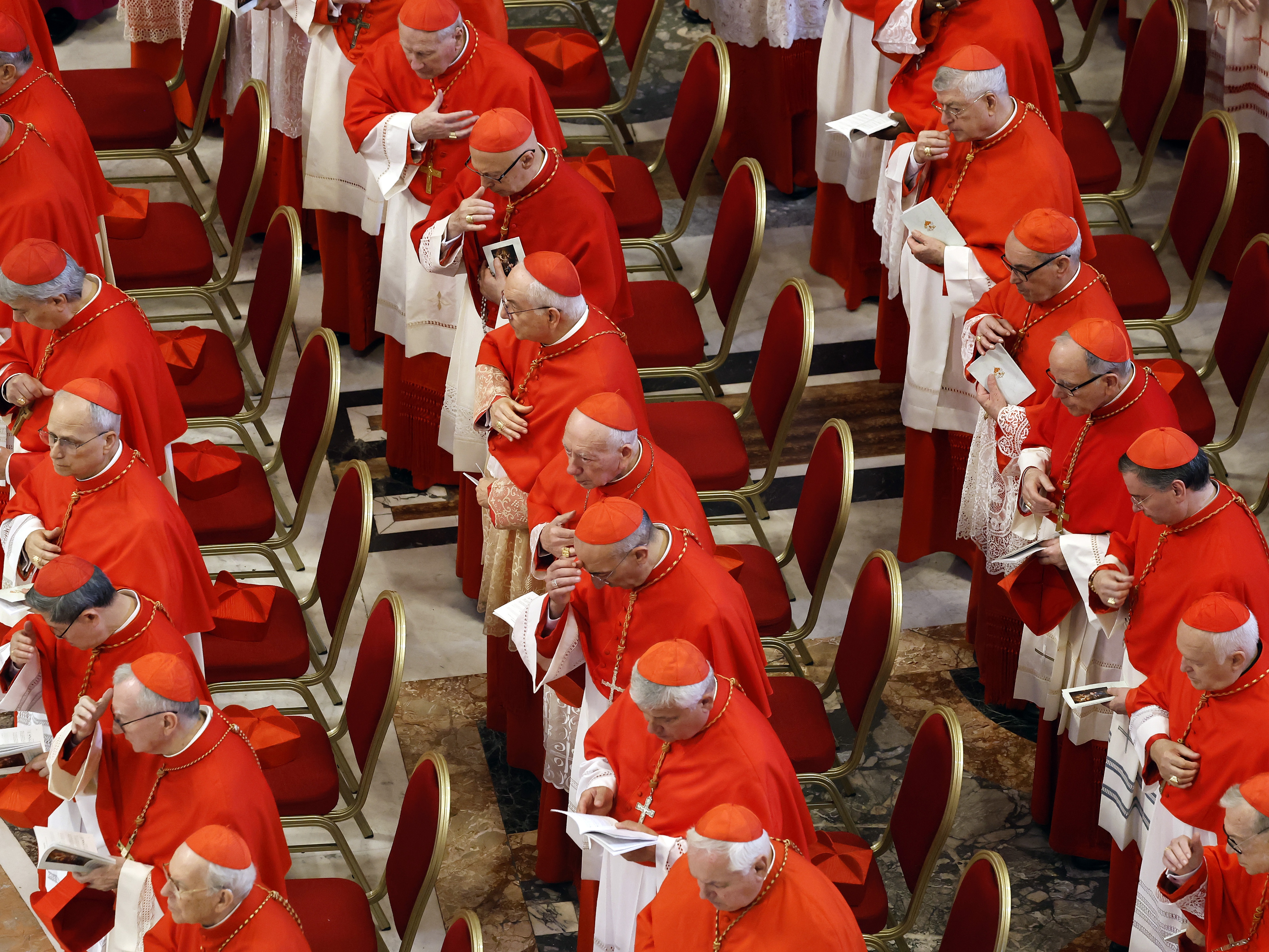 caption: Cardinals look on as the body of Pope Francis is transferred into the Basilica at St Peter's Square in Vatican City on Wednesday. The College of Cardinals is preparing for a conclave to elect the next pontiff, after days of funeral rites and observances conclude.