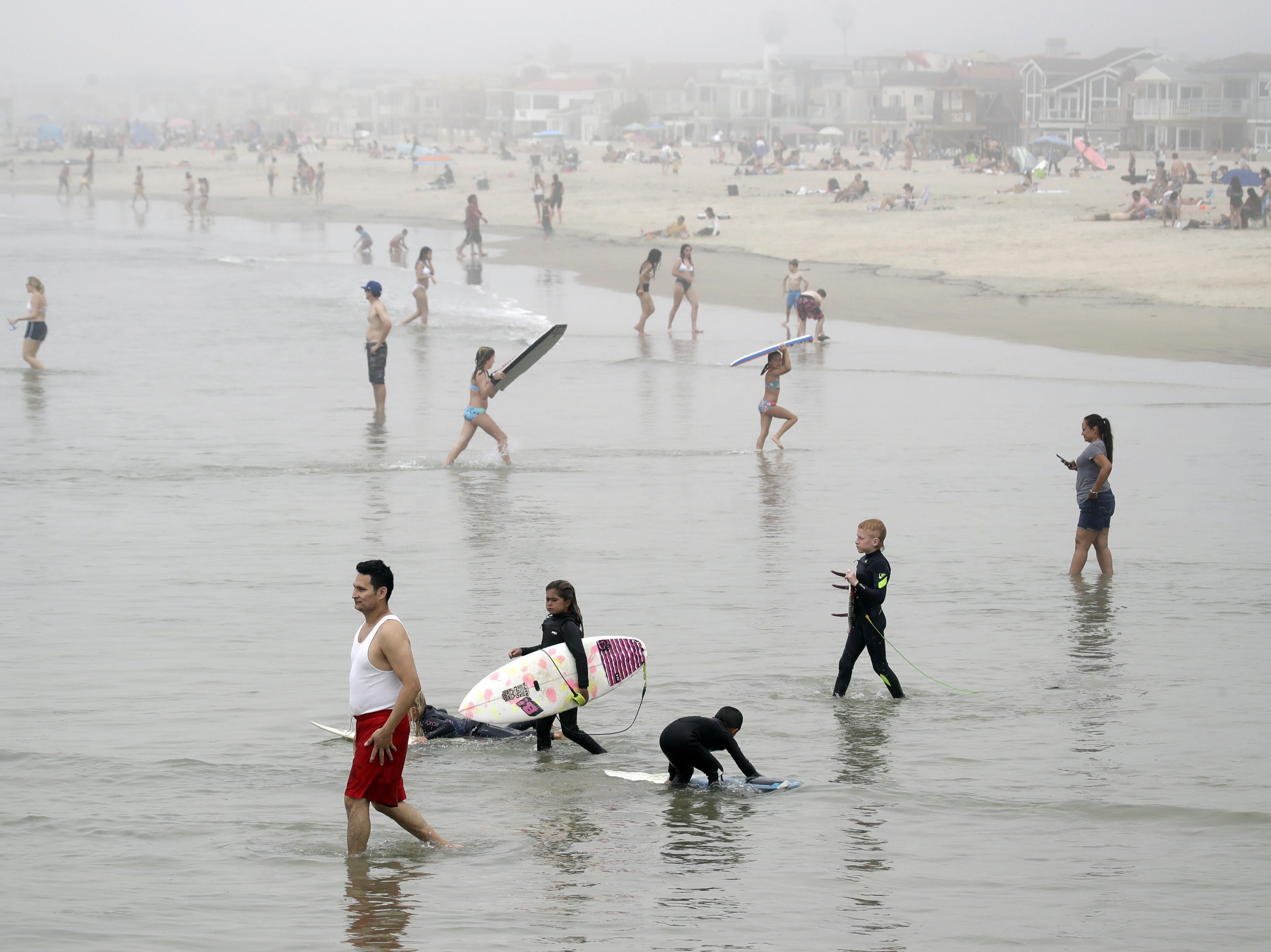 caption: Crowds descend upon Newport Beach, Calif., last Sunday. Gov. Gavin Newsom warned that defiance of stay-at-home orders could put the state's progress in fighting the coronavirus at risk.