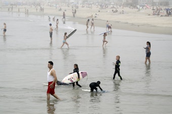 caption: Crowds descend upon Newport Beach, Calif., last Sunday. Gov. Gavin Newsom warned that defiance of stay-at-home orders could put the state's progress in fighting the coronavirus at risk.